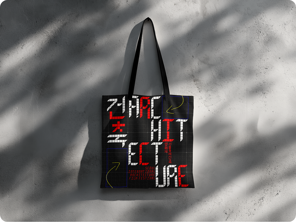 Black tote bag featuring bold pixel-style typography and red accents related to an architecture film festival.